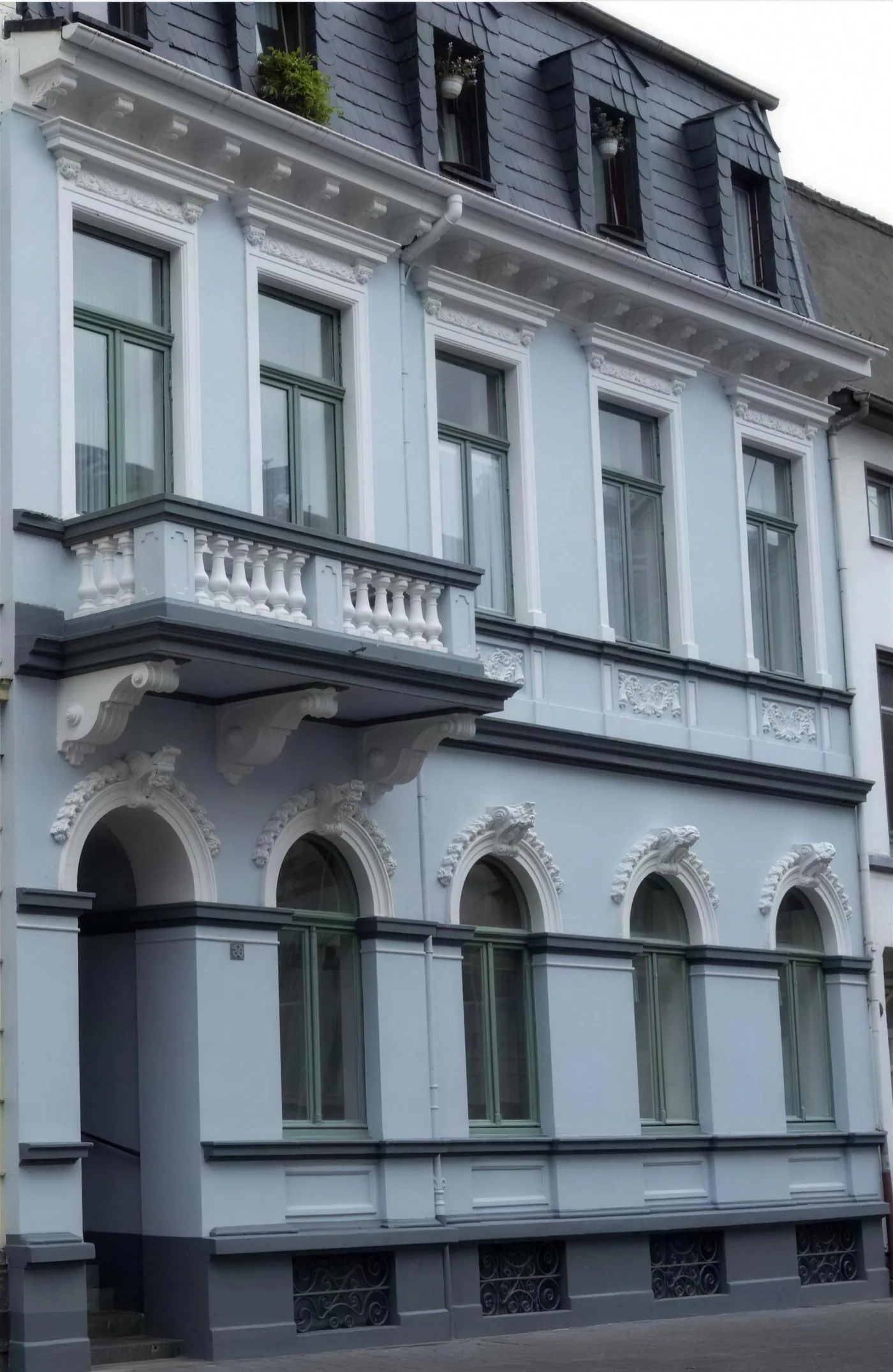 Gründerzeitfassade in Hellblau mit weißen Stuckelementen